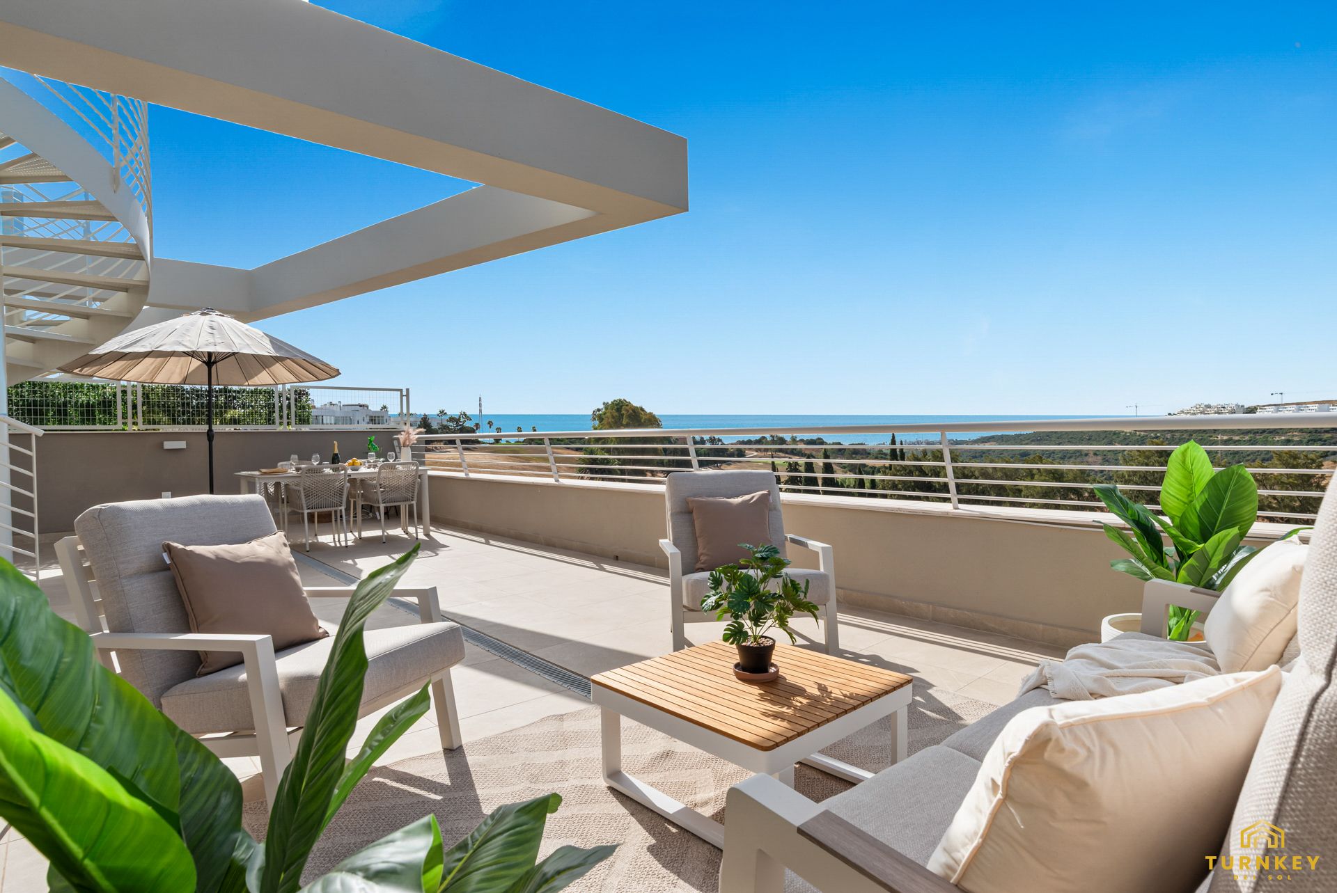 Dakterras van het penthouse met loungeset en uitzicht op zee